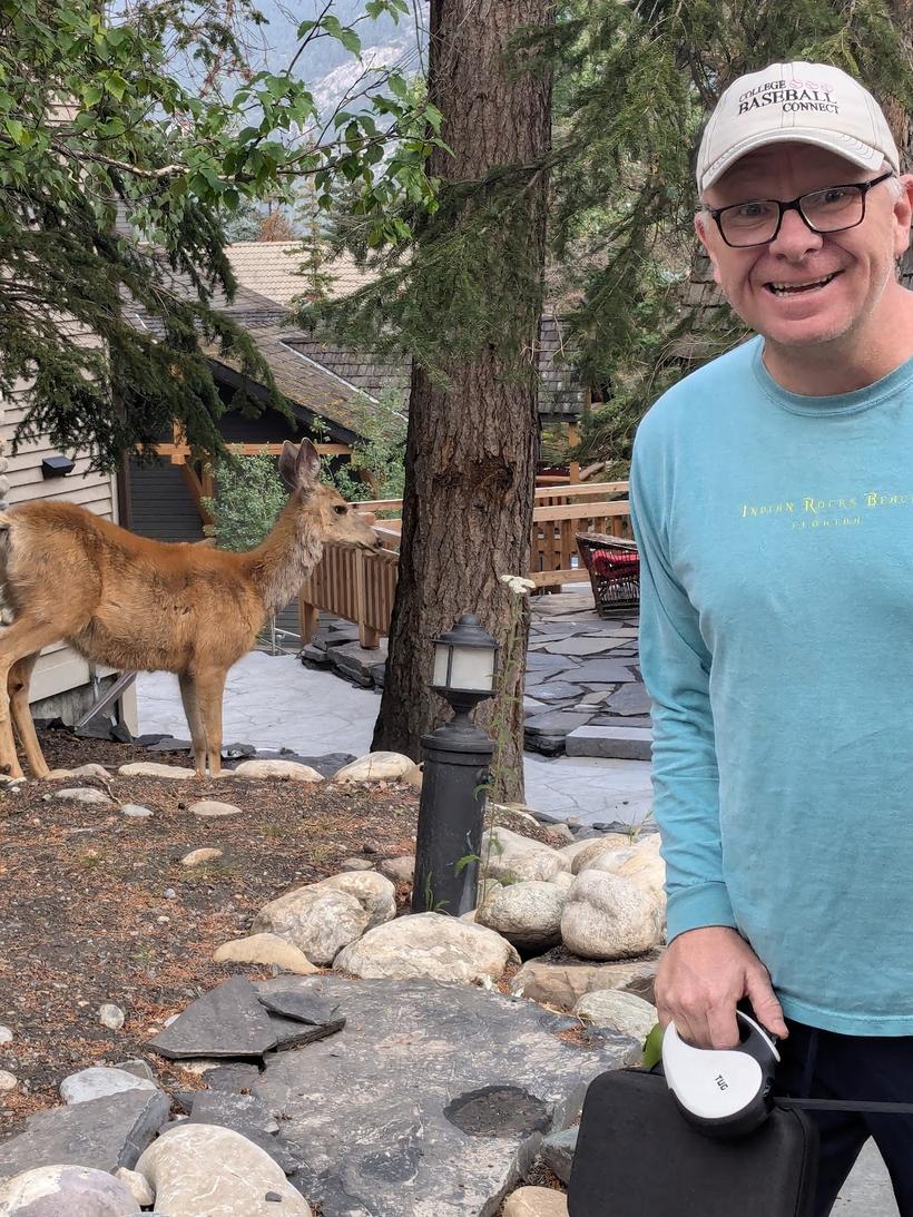 Andrew the Cayman Trader with a mule deer wandering past in the mountains